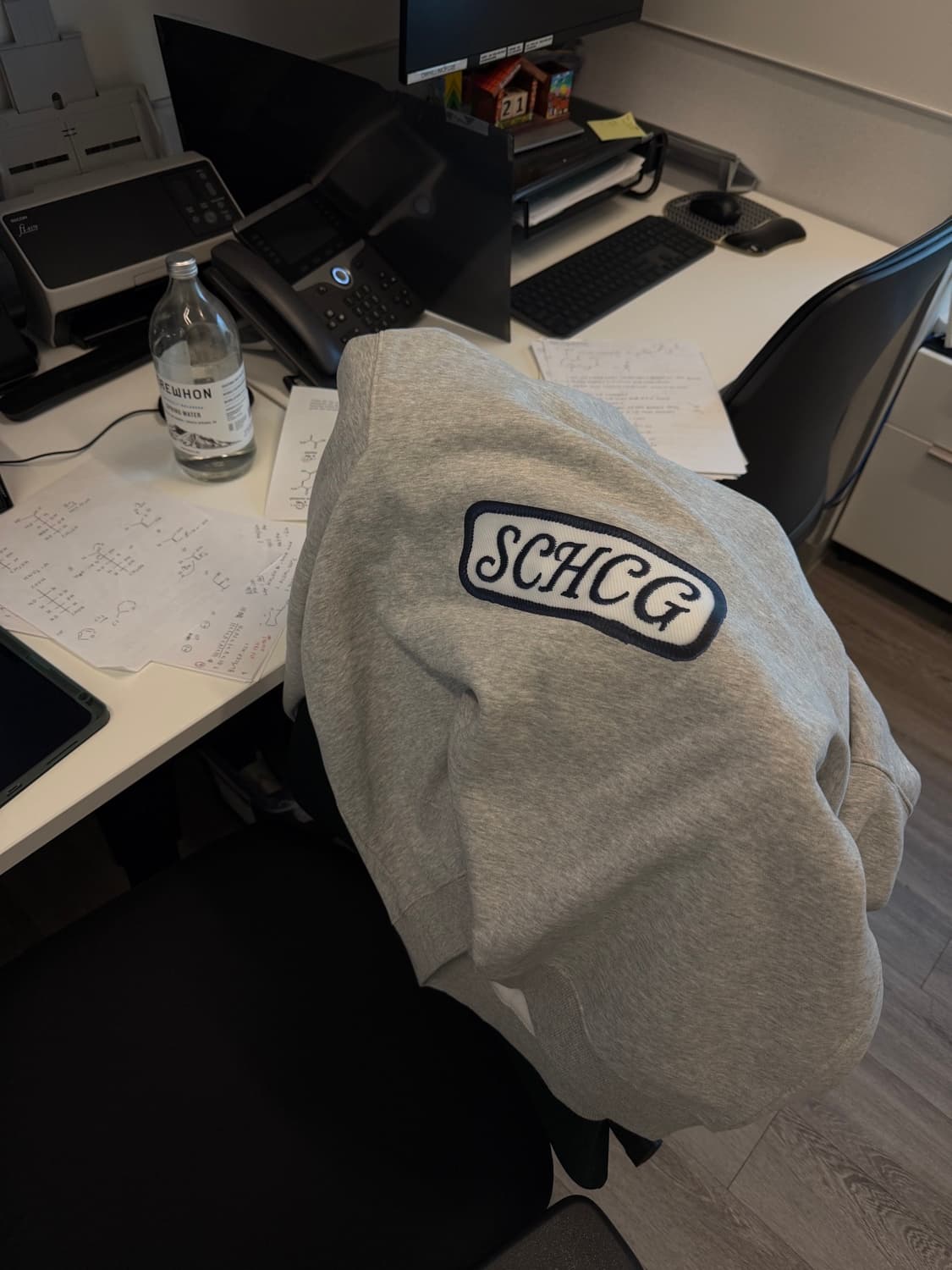 An SCHCG crewneck on a desk